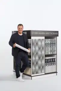 Guido Kretschmer vor einem Tapetenpresenter.